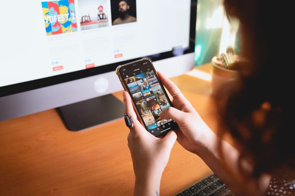 Planning social posts on a phone at a desk