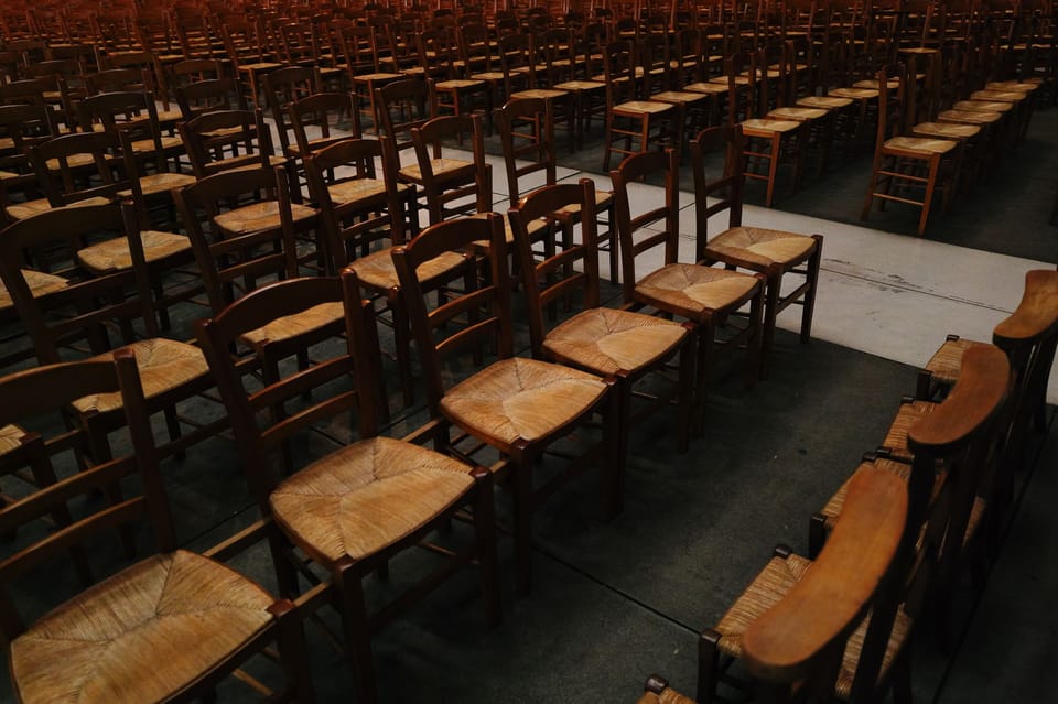 An empty hall with chairs stacked at the side